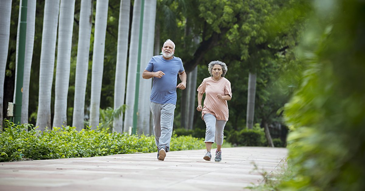 Indian senior couple walking briskly in a park in the morning